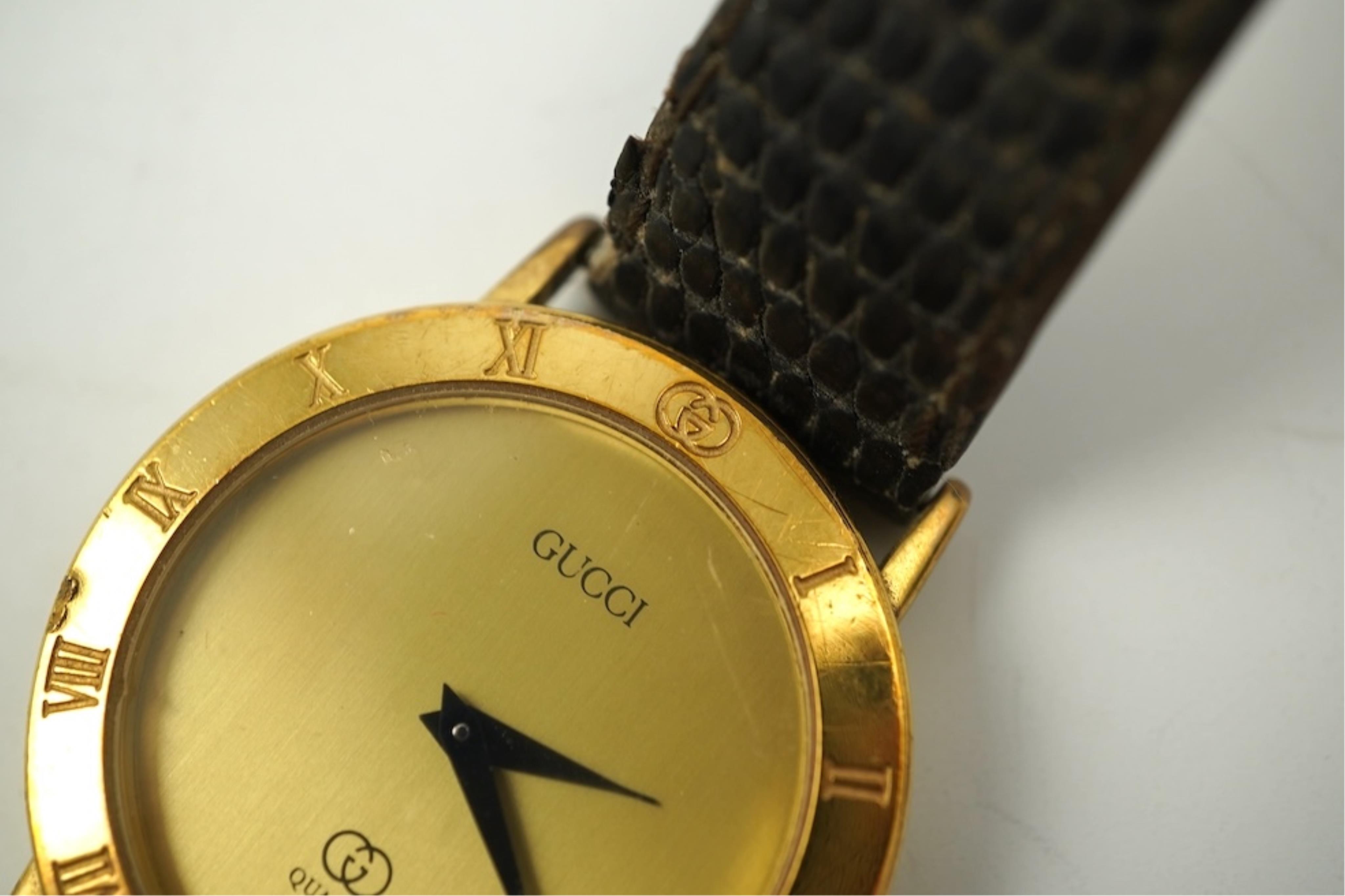 A gentleman's recent 18k gold electro-plated Raymond Weil quartz dress wrist watch, case diameter 33mm and a similar Gucci quartz dress wrist watch.